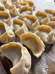 Homemade Handmade Dumplings on Wooden Cutting Board – Flour-Sprinkled Rustic Scene for Healthy Cooking & Preserves