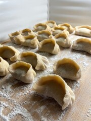 Homemade Handmade Dumplings on Wooden Cutting Board – Flour-Sprinkled Rustic Scene for Healthy Cooking & Preserves
