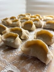 Homemade Handmade Dumplings on Wooden Cutting Board – Flour-Sprinkled Rustic Scene for Healthy Cooking & Preserves