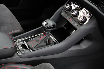 Automatic transmission of car close-up. Interior of new car in Alcantara with red stitching. Gear...