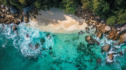Aerial wave crashing against golden beach, green and white foam. 
