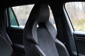 Sports car seats in the interior of a sports car. Premium sport car driver's seat in gray Alcanta seat with powerful lateral support. Sport car interior.