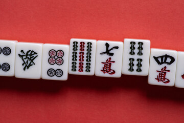Fototapeta na wymiar 赤背景に並ぶマージャン牌