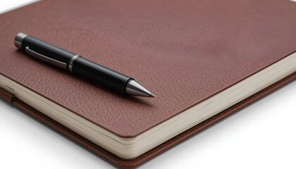 A close up of a black pen resting on top of a brown leather bound notebook on a white background surface .