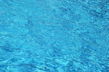 Obraz na płótnie Canvas Blue water background on a sunny day. Beautiful texture of sun glare on the water surface.