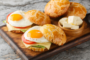 Hong Kong Style Fried Eggs Sandwich with tomato, cheese, lettuce close-up on wooden board on table....
