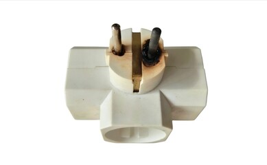 Damaged electrical three holes domestic power socket burn marks isolated on white background.