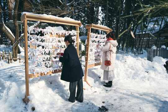 神社でおみくじを結ぶ日本人女性