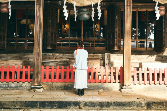 神社でお参りをする日本人女性