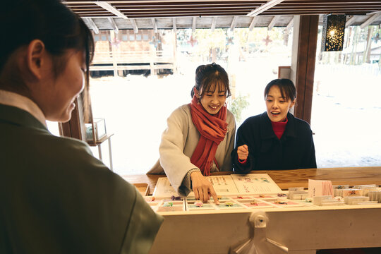 神社でお守りを買う日本人女性