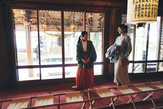 巫女さんに神社の案内をしてもらう日本人女性