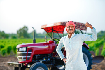 indian farmer standing with tractor at field
