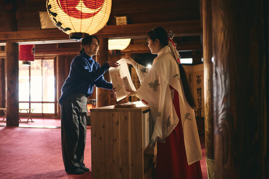 神社でお札を受け取る日本人女性