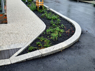 Water from the road is absorbed through the gaps in the curb and the slope of the asphalt towards...