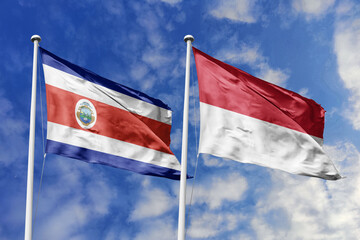 Costa Rica and Monaco flags proudly waving against a vibrant blue sky, symbolizing international...