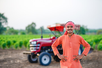 indian farmer standing with tractor at field