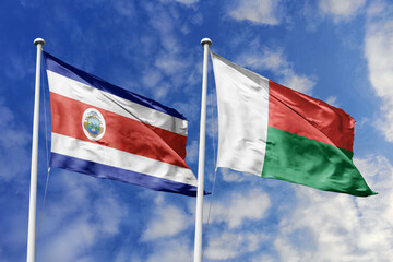 Costa Rica and Madagascar flags proudly waving against a vibrant blue sky, symbolizing...