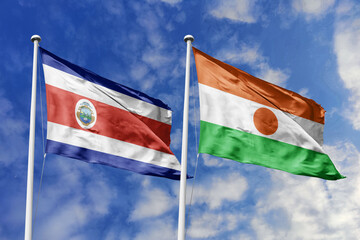 Costa Rica and Niger flags proudly waving against a vibrant blue sky, symbolizing international...