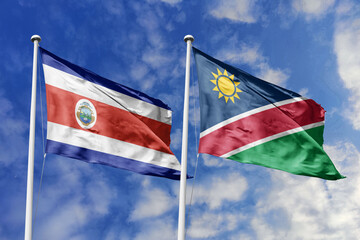 Costa Rica and Namibia flags proudly waving against a vibrant blue sky, symbolizing international...