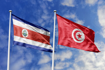 Costa Rica and Tunisia National Flags Billowing Together Under a Clear Blue Sky, Representing Diplomatic Harmony and International Relations.