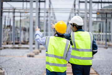 Engineer and power specialist working together at high voltage substation performing infrastructure inspection and check to ensure safety and efficiency in electrical system