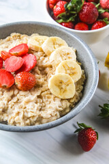 a bowl of oatmeal with strawberries and bananas