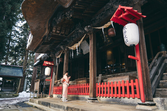 神社にお参りをする着物姿の日本人女性