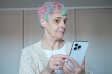 I see no good reason to act my age. A cheerful elderly woman with multi-colored hair using...