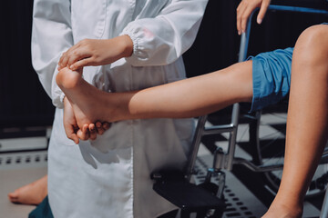 Physiotherapist checking knee of female patient stock