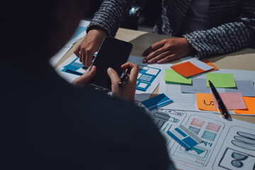 Group of young application developers analyzing uxui mobile app templates during a working meeting