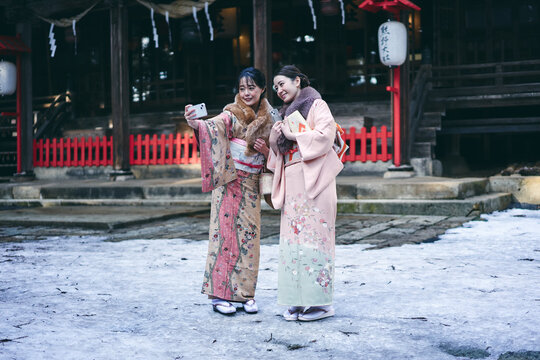 神社で写真を撮る着物姿の日本人女性