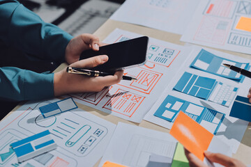 Group of young application developers analyzing uxui mobile app templates during a working meeting