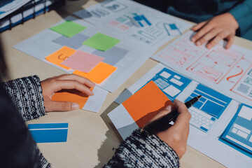 Group of young application developers analyzing uxui mobile app templates during a working meeting