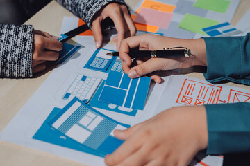 Group of young application developers analyzing uxui mobile app templates during a working meeting