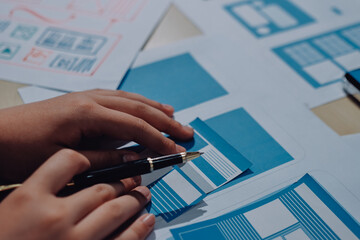 Group of young application developers analyzing uxui mobile app templates during a working meeting