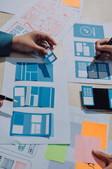 Group of young application developers analyzing uxui mobile app templates during a working meeting