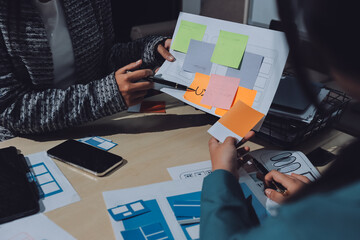 Group of young application developers analyzing uxui mobile app templates during a working meeting