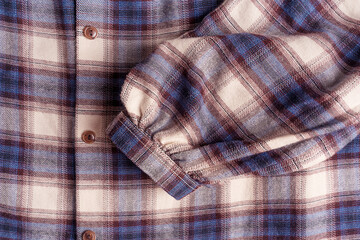 Background or backdrop of close-up top view of blue and purple brown plaid flannel cotton checkered...