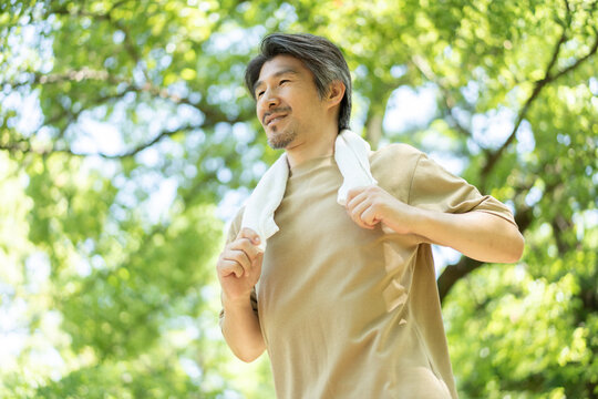 公園を走るミドル男性 - Powered by Adobe