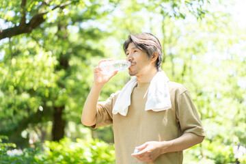 Fototapeta premium 公園で水を飲む男性