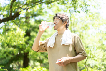 公園で水を飲む男性