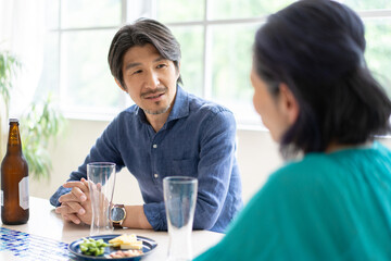 食卓で会話をする夫婦