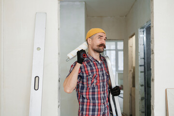 construction worker guy with a drill on a white wall background.master for an hour.