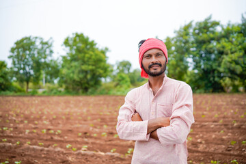 young indian farmer standing at field