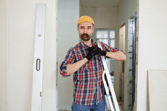 construction worker guy with a drill on a white wall background.master for an hour.