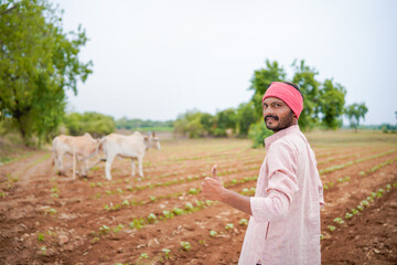 young indian farmer standing at field
