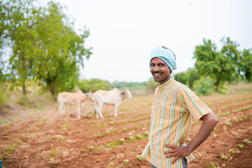 young indian farmer standing at field