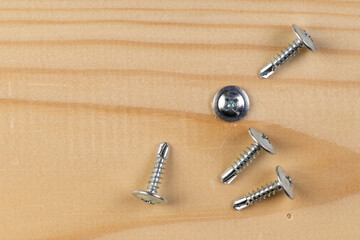 pine board and steel self-tapping screws for wood, silver self-tapping screws for wood on the board