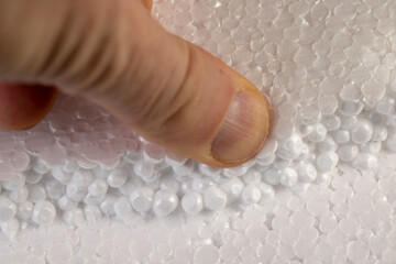 white foam made from a large number of spherical pieces joined together. touching the material with...