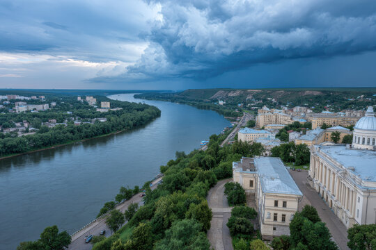 stunning panorama of ancient building in cheboksary emphasizing flowing river and dramatic clouds above